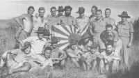 Members of the New Guinea 
Volunteer Rifles display a Japanese flag captured at Mubo on 21st July 1942
