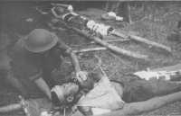 Japanese, wounded in the 
final Australian assault on Gona, lie on rough bush stretchers, awaiting evacuation