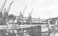 Close-up of damaged dock 
facilities and sunken craft, 1 September 1944