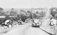 Abandoned German Equipment 
Litters a Road to Avranches