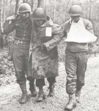 Wounded soldier helped to 
aid station, after fighting in the Forêt de Grémecey