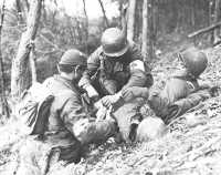 Medics aid a wounded 
soldier in the woods