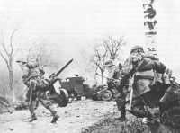 German Troops Advancing 
Past Abandoned American Equipment