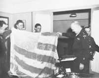 Lieutenant Robertson 
(extreme left) shows General Eisenhower the makeshift flag displayed at the Elbe