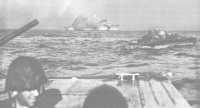 Supporting cruiser fires 
on targets on Tinian as LVTs carrying assault troops head toward the White Beaches