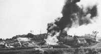 BLOWTORCH: A flame tank 
burns out Japanese positions in hillside tombs during the drive for Naha