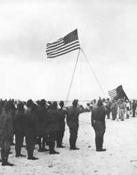 To the Colors sounds as the 
American flag is raised over Wake Island for the first time since December 1941