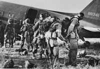 Paratroopers, identified 
by white arm bands, preparing to emplane for Sicily