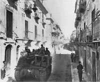 Tank-mounted CCA men push 
through Palma en route to Naro