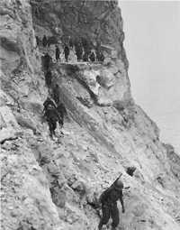 30th Infantry Troops moving 
around the Cape Calavà cliff where the roadbed had been blown out by the Germans