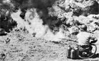 Testing an unused 
flame-thrower abandoned at the Ilu by the Japanese