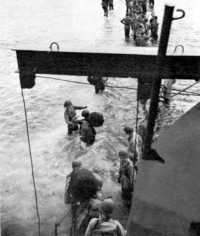 Troops Disembarking from 
LCI at Kiriwina Island wade ashore, 30 June 1943