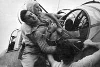 Aircrewman wounded in 
strike on Rabaul is helped out of his plane on flight deck of aircraft carrier USS Saratoga, 5 November 1943