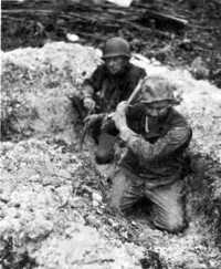 Digging a foxhole through 
coral rock near the airstrip, 29 February 1944