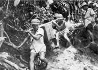 Filipino carriers haul 
supplies over slippery mountain trails for the 12th Cavalry