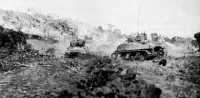Fighting toward Hill 89, 
tanks of the 769th Tank Battalion attack a bypassed Japanese strong point