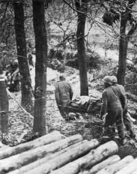 Evacuation of wounded over 
the muddy ground of the Hürtgen Forest