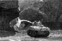 Medium tank equipped with 
flame thrower firing on entrance to enemy cave