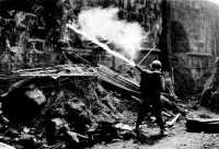 Firing an M2-2 portable 
flame thrower into a wall opening, Manila, Luzon, February 1945