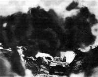 Flame-throwing tank attacks 
enemy infantrymen dug in along an old road on Okinawa