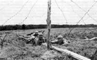 Engineers at Camp Swift, 
Texas, push a bangalore torpedo under barbed wire entanglement during a training exercise, June 1943