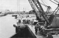 Members of port 
construction and repair group repairing a lock gate to a basin at the harbor, Le Havre, France