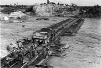 The rising Arno river 
threatens a treadway bridge in the 1st Armored Division area, September 1944