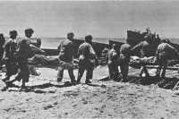 Evacuating wounded to 
landing craft for return to transports, Gela area, 12 July