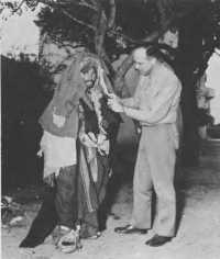 Colonel Stone inspecting 
clothing of a lice-infested Arab in Tunisia