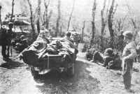 Medics of 10th Mountain 
Division evacuating wounded in a jeep while tanks wait to use the one-lane road, April 1945
