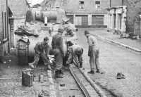 Track extensions being 
installed by the crew of a Sherman tank during a lull in combat operations at Baesweiler, Germany