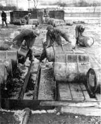 Emptying gasoline drums 
into “catch basins” in Seventh Army area, January 1945