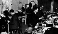 Newsmen at work in an 
improvised press wireless room (below)